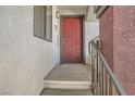 Entryway to a condo with a red front door and textured exterior walls at 950 Seven Hills Dr # 424, Henderson, NV 89052