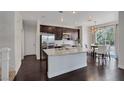 Modern kitchen with stainless steel appliances, large island, granite countertops, and dark wood floors at 10004 W Cherokee Ave, Las Vegas, NV 89147
