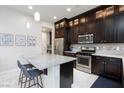 Bright kitchen with stainless steel appliances, dark cabinetry, and a marble island with seating at 10356 Addie De Mar Ln, Las Vegas, NV 89135