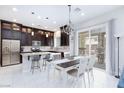 Modern kitchen with dark cabinets, stainless steel appliances, a kitchen island, and sliding glass doors at 10356 Addie De Mar Ln, Las Vegas, NV 89135