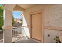 Front porch with neutral-colored door, decorative pillars, and wrought iron railing for a secure feel at 1405 Sycamore Spring Ct, Las Vegas, NV 89128