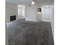 Spacious living room with neutral gray carpet, fireplace, and open layout at 1621 Sandecker Ct # 104, Las Vegas, NV 89146
