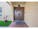 Welcoming front entrance to the home with double doors and decorative plants at 1709 Chapman Dr, Las Vegas, NV 89104