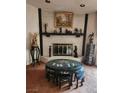 Living room with a brick fireplace with mantle and decor and small, round asian inspired table at 1801 Calle De Vega, Las Vegas, NV 89102