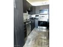 Stylish kitchen featuring sleek black cabinetry, stainless steel appliances, and mosaic backsplash at 2455 W Serene Ave # 709, Las Vegas, NV 89123