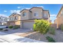 Tan two-story home with a brick driveway and desert landscaping at 2878 Chalk Mountain Ct, Las Vegas, NV 89142