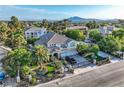 Stunning aerial view of a beautiful home featuring lush landscaping and a gated entrance, with mountain views in the background at 3560 Five Pennies Ln, Las Vegas, NV 89120