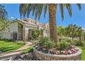 Beautiful front yard with a flower bed, healthy trees, stone pathway, and view of the two-story home at 3560 Five Pennies Ln, Las Vegas, NV 89120