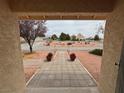View from covered front porch; landscape features desert rock and gravel, potted plants, and small trees at 3580 Unicorn Ave, Pahrump, NV 89048