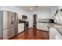 Bright kitchen with stainless steel appliances, white cabinets, and granite countertops; hardwood floors at 5010 Mick Pl, Las Vegas, NV 89103