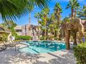 Resort-style pool area with lounge chairs, tiki umbrellas, and lush landscaping, perfect for relaxation at 5250 S Rainbow Blvd # 1131, Las Vegas, NV 89118