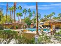 Inviting pool area with a rock waterfall feature, tiki umbrellas, and lounge chairs for relaxation at 5250 S Rainbow Blvd # 1131, Las Vegas, NV 89118