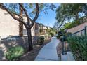 Serene walkway with lush landscaping and a stone retaining wall, providing a tranquil outdoor experience at 5253 Westwind Rd, Las Vegas, NV 89118
