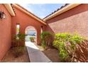 The charming entryway features a walkway lined with lush greenery leading to the front door at 5518 Ovando Way, Las Vegas, NV 89122