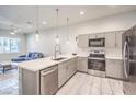Bright kitchen boasts a breakfast bar, stainless appliances, and modern pendant lighting at 6437 Wide Sky St, Las Vegas, NV 89166