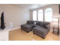 Comfortable living room features a large sectional sofa, bright natural light, and hardwood flooring at 6493 Yellow Bells Ct, Las Vegas, NV 89131