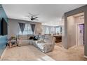 Cozy living room featuring plush seating, soft carpeting, and a view into the kitchen area at 7109 Red Gulch St, North Las Vegas, NV 89084
