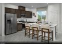 Modern kitchen features stainless steel appliances, a center island with bar stool seating, and dark wood cabinets at 890 Apatite Pl # Lot 68, Henderson, NV 89011