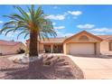 Inviting single-story home featuring a desert-landscaped front yard and a distinctive palm tree enhancing curb appeal at 9305 Quail Ridge Dr, Las Vegas, NV 89134