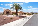 Beautiful single-story home with desert landscaping and a symmetrical layout, complemented by a mature palm tree at 9305 Quail Ridge Dr, Las Vegas, NV 89134