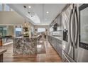 Open kitchen with a granite island, stainless appliances, and hardwood floors at 19 Hilltop Crest St, Henderson, NV 89011