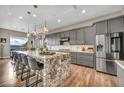 Modern kitchen featuring gray cabinets, stainless steel appliances, and a large island with seating at 19 Hilltop Crest St, Henderson, NV 89011