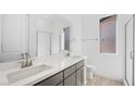 Modern bathroom with double sinks, gray cabinets, quartz countertop, and a glass shower door at 352 Tigullio Ave, Henderson, NV 89011