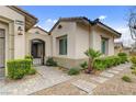 Elegant front entrance with a gated courtyard, lush landscaping, and stone pathway at 730 Puerto Real Ct, Las Vegas, NV 89138