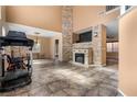 Bright living room featuring tile flooring, a stone fireplace, and ample natural light at 10437 Walworth Ave, Las Vegas, NV 89166