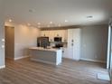 Open-concept kitchen with island, stainless steel appliances, and white cabinetry at 3232 Walker River St, North Las Vegas, NV 89032