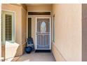 A cozy front porch featuring a decorative glass-paneled security door and neutral stucco at 3665 Cottage Stone Ct, Laughlin, NV 89029