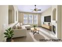 Bright, staged living room featuring a fireplace, ceiling fan, large windows and comfortable seating at 10550 W Alexander Rd # 2103, Las Vegas, NV 89129