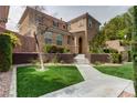 Inviting two-story home featuring a manicured lawn and a neutral color palette at 10616 Olympic Pine Dr, Las Vegas, NV 89135