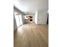 Spacious living room with light wood floors leading to a kitchen and sliding glass doors at 4421 Alexis Dr # 429, Las Vegas, NV 89103