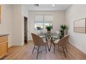 Cozy dining area with modern glass table, pendant lighting, and a window offering natural light at 1047 Amber Gate St, Henderson, NV 89002