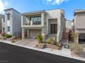 Inviting two-story house with a balcony, attractive landscaping, and a paved driveway at 10806 Space Odyssey Ave, Las Vegas, NV 89129