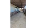 Spacious covered driveway with exposed concrete and access to the side of the home at 116 Continental Ave, Henderson, NV 89015