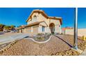 View of home's exterior featuring drought-resistant landscaping, a front yard, and two-car garage at 1532 Ascension Cir, North Las Vegas, NV 89031