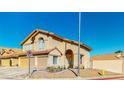 Tan two-story home with a two-car garage and desert landscaping at 1532 Ascension Cir, North Las Vegas, NV 89031