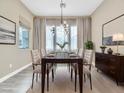 Elegant dining room with modern chandelier, dining table set for six, and light gray walls at 1536 Unison Way # 102, Las Vegas, NV 89135