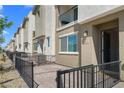 A townhome's entry featuring a stone-paved patio with a black metal fence at 2677 Saddle Bronze Ct, North Las Vegas, NV 89086