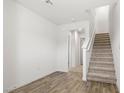 A living room featuring wood flooring, a staircase, and white walls at 2677 Saddle Bronze Ct, North Las Vegas, NV 89086
