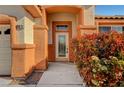 Close-up showcasing the decorative glass front door and colorful landscaping by the entryway at 3071 Misty Moon Ave, Henderson, NV 89052