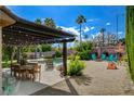 Lovely outdoor living space with pergola, dining table, fire pit, and refreshing pool at 4617 Gonzales Dr, Las Vegas, NV 89130