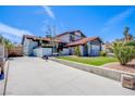 Home featuring a red tile roof, landscaped front yard, and an attached two-car garage and long driveway at 5301 Kalmia Dr, Las Vegas, NV 89103