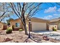 Charming home featuring a well-maintained front yard, desert landscaping, and a two-car garage for convenience at 5681 Harbour Pointe Ave, Las Vegas, NV 89122