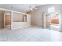 Bright living room featuring vaulted ceiling, tile flooring and sliding glass door access to the backyard at 6149 Elderberry Wine Ave, Las Vegas, NV 89142