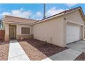 Inviting single-story home showcasing a two-car garage, neutral exterior, and a tidy gravel yard at 6314 Shadow Moon Pl, North Las Vegas, NV 89031