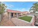 Lush backyard features a brick patio, synthetic grass, and plenty of space for outdoor living and entertainment at 635 Dry Valley Ave, North Las Vegas, NV 89031