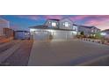 Home with a large driveway, lush landscaping, and a three-car garage at 6927 Adobe Villa Ave, Las Vegas, NV 89142